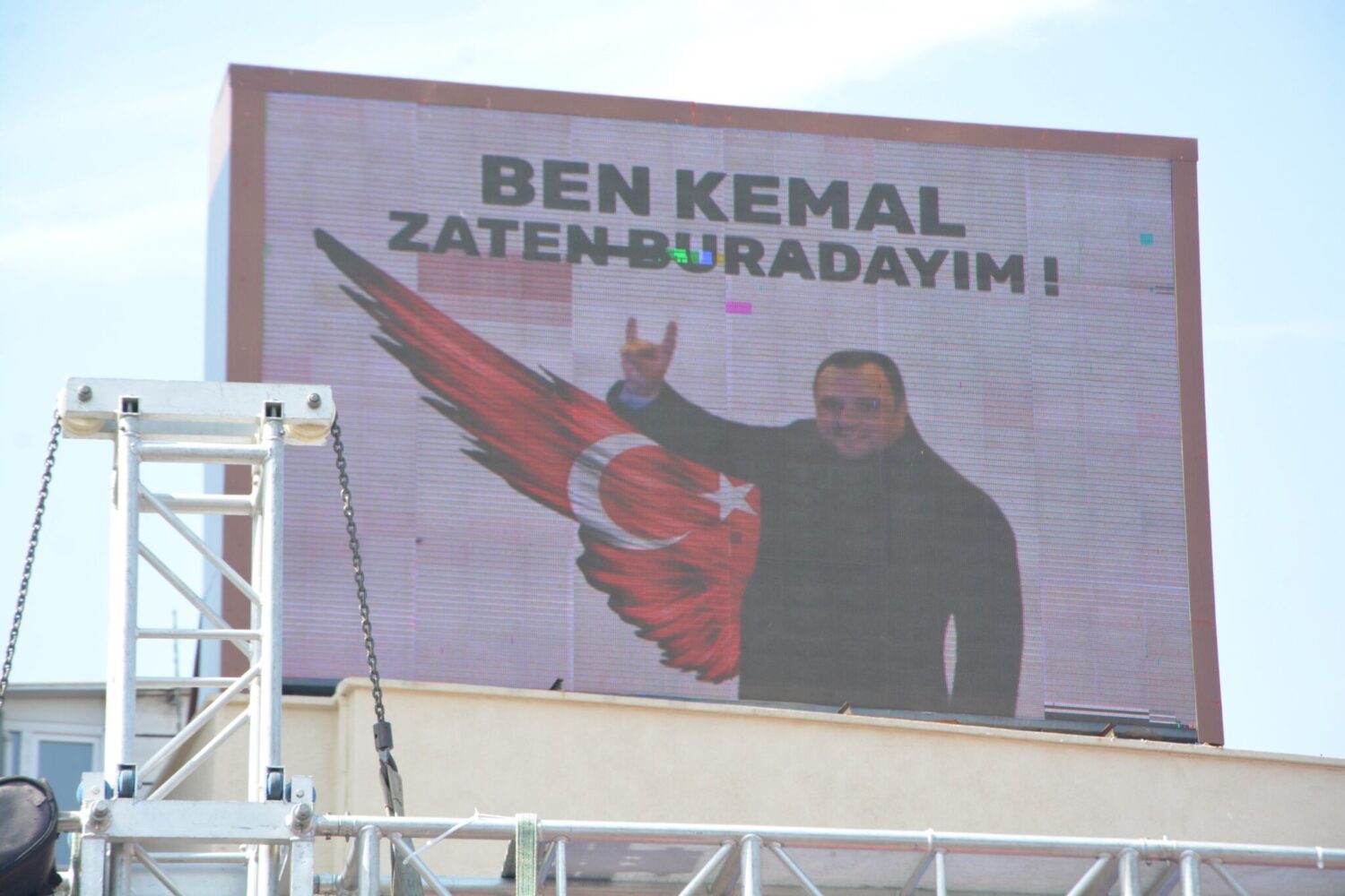 Balıkesir'de Cumhuriyet Halk Partisi'nin aday tanıtım töreninde ilginç bir olay yaşandı. CHP'lilerin yürüyüş sonrası geldiği meydandaki dijital reklam alanında beliren, "Ben Kemal, zaten buradayım" yazılı reklam herkesin dikkatini çekti.