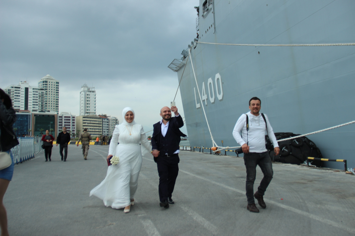 İzmir'de düğünlerinin ardından hemen TCG Anadolu gemisini ziyaret etmek isteyen genç çift, Alsancak Limanı'na geldi. Geminin İzmir'de olması fırsatını kaçırmak istemeyen çift, gelinlik ve damatlıkla birlikte TCG Anadolu'da fotoğraf çektirdi.