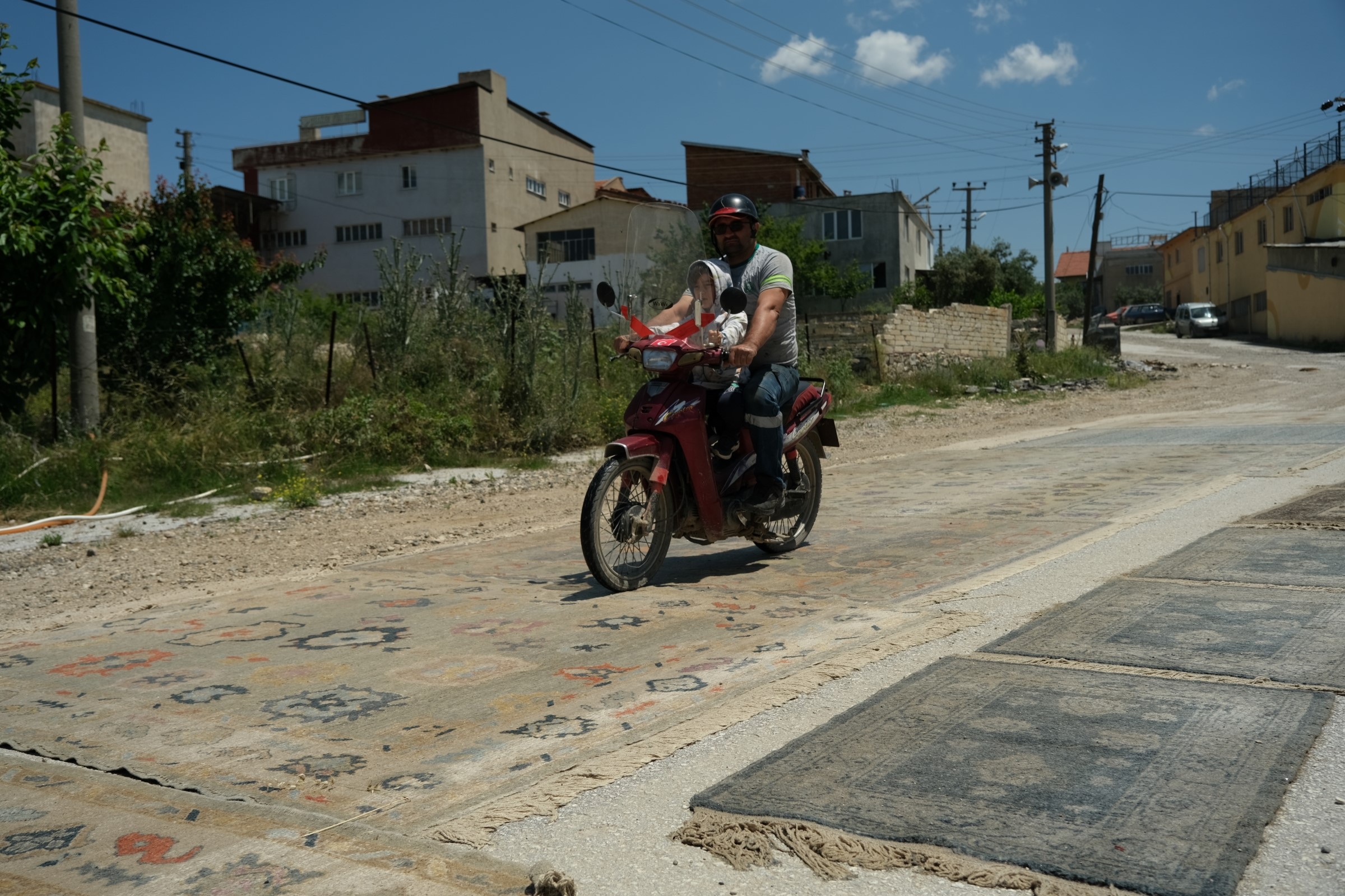 Manisa'nın Demirci ilçesinde, dokunan halılar eskitilmek amacıyla yollara seriliyor. Kadınlar tarafından özenle dokunan halılar, güneşte bekletilerek ve üzerinden araçların geçmesiyle antika bir görünüm kazanıyor. Bu sıra dışı işlem sonucunda elde edilen halılar, ihraç edilerek Amerikalıların evlerini süslüyor.