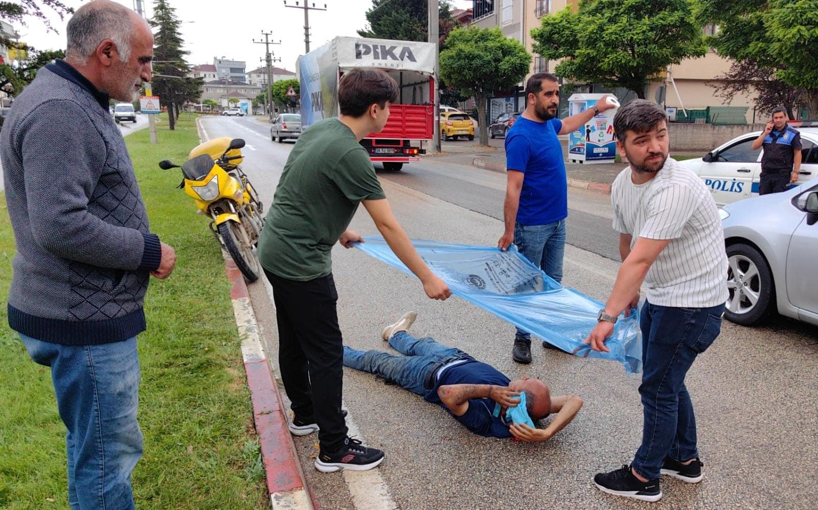 BURSA'NIN İNEGÖL İLÇESİNDE MEYDANA GELEN KAZADA DEVRİLEN MOTOSİKLETTEN DÜŞEN GÖREVLİ YARALANDI. YAĞIŞ NEDENİYLE YARALANARAK YERE DÜŞEN GÖREVLİYİ, VATANDAŞLAR YAĞIŞTAN ÇÖP POŞETİ İLE KORUDU. (SALİH BİLAL ASLAN/BURSA-İHA)