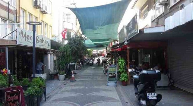 Balıkesir’in Edremit ilçesinde, ülke genelinde yaşanan çöl sıcaklıkları nedeniyle bunalan esnaf çareyi sokağın üzerine zeytin brandaları germekle buldu.