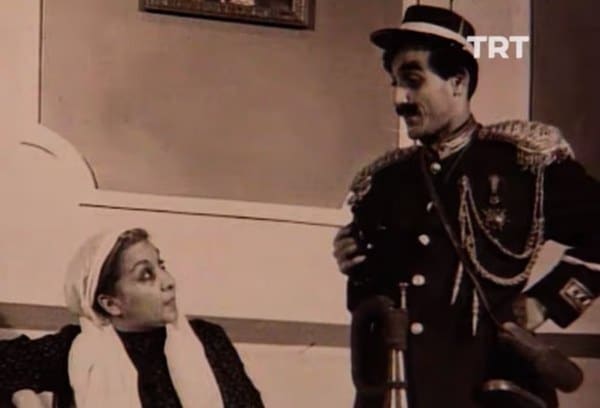 Aslen Rum asıllı tulûat ustası Komik-i Şehir Naşit Bey ile Ermeni asıllı tiyatro oyuncusu ve kantocu Amelya Hanım’ın oğlu olarak 15 Ağustos 1928’de İstanbul’da dünyaya geldi. Amelya Hanım'ın annesi zamanının meşhur kantocularından Osmanlı Ermenisi Küçük Virjin, babası ise Osmanlı Rumu, Kemani Yorgo Efendi'dir.