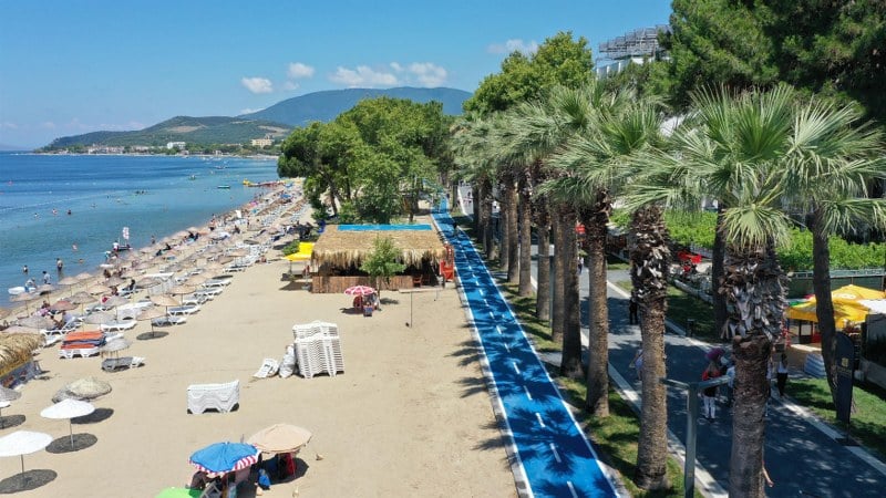 Balıkesir Büyükşehir Belediye Başkanı Yücel Yılmaz’ın talimatı ve gelecek vizyonu doğrultusunda, Erdek'in doğal güzelliklerine değer katan muhteşem bir projeye imza attı. Erdek'in incisi sahiller adeta yeniden doğdu! Çuğra, Narlı, Çakıl, Tatlısu Büyükbakraç ve Şahinburgaz sahilleri, şimdi misafirlerine daha modern, daha konforlu ve daha çekici bir deneyim sunuyor. Yenilenen altyapı, sahil yolları ve bisiklet yollarıyla birlikte, ziyaretçilerin rahatça gezinti yapabileceği, spor yapabileceği ve doğanın tadını çıkarabileceği bir ortam oluşturuldu.